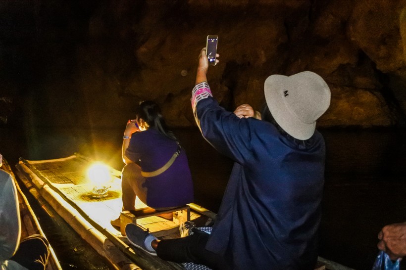 撑着竹筏在地下溶洞探险的人物图片