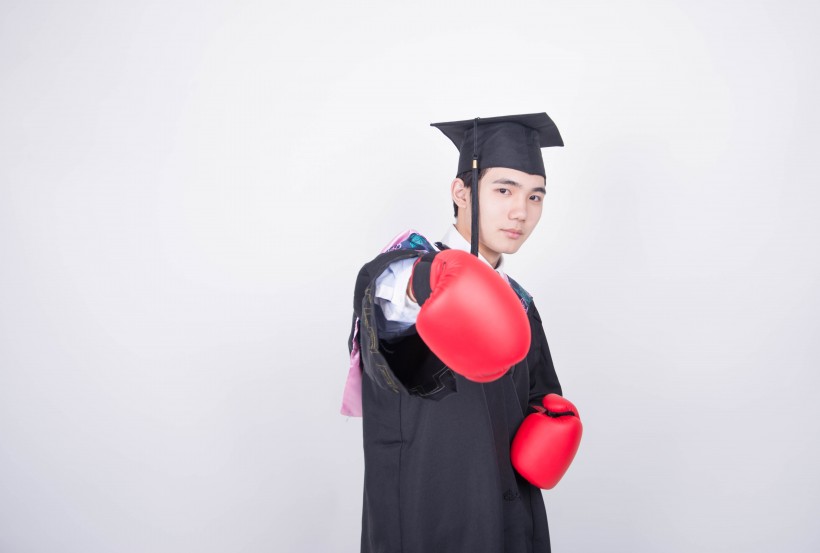 文武双全的大学毕业生训练拳击图片