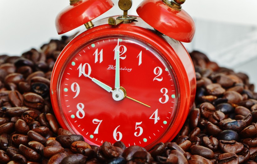 红色闹钟和咖啡豆放在一起图片