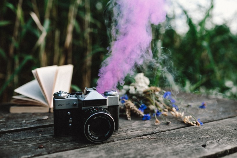 色彩斑斓的烟雾弹,书和古董相机图片