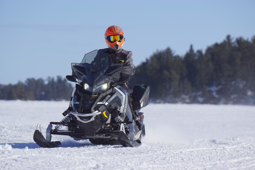 在雪山里開著雪地車的人圖片