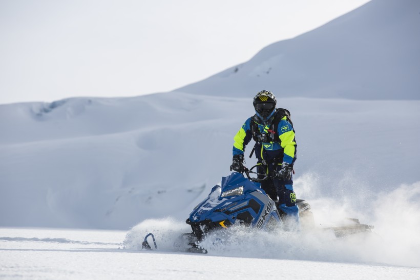 在雪山里開(kāi)著雪地車(chē)的人圖片