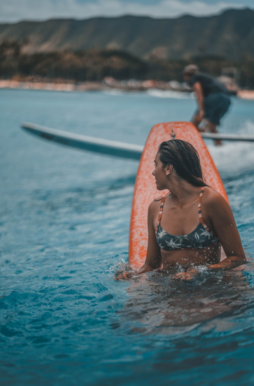 海邊抱著沖浪板的女子圖片