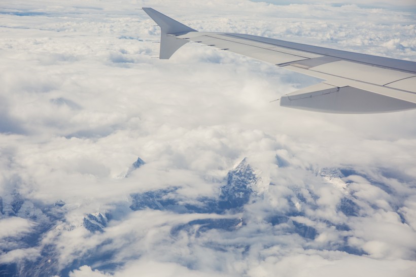 高空云層上的飛機機翼圖片