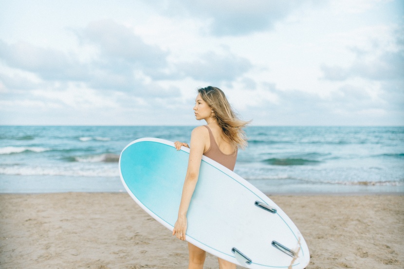 海边抱着冲浪板的女子图片