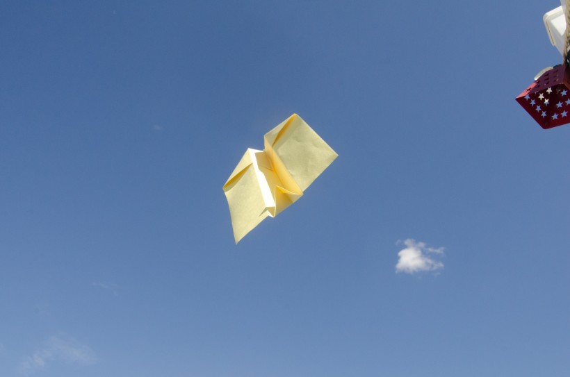 在飞的黄色纸飞机图片
